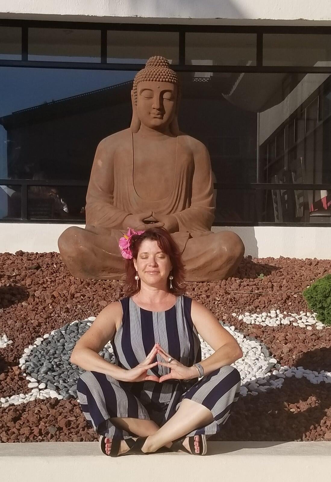 Shanley sitting with a Buddha statue